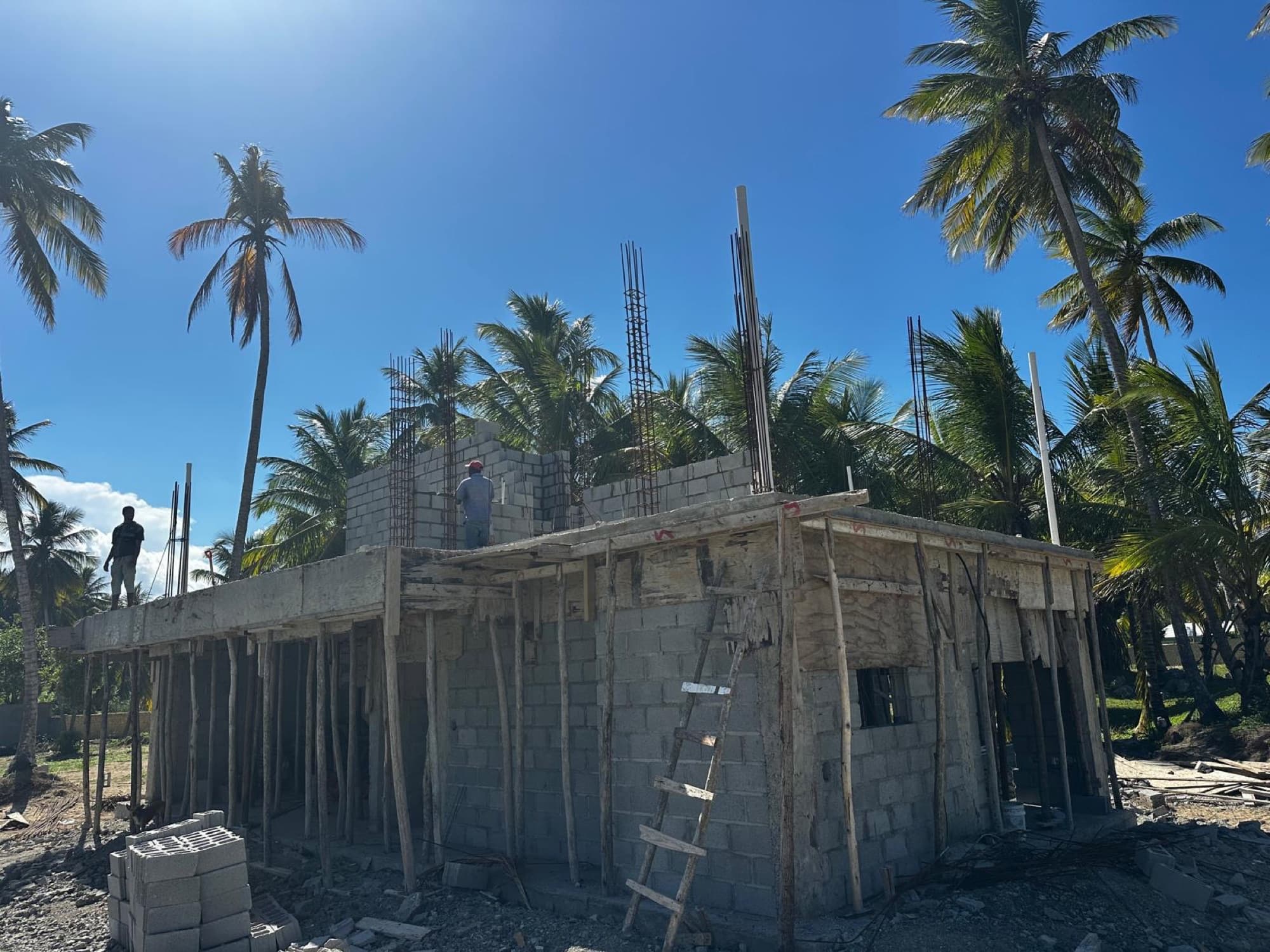 Villa on lot 5: ground-floor block walls complete, the first-floor slab in place, and the second-level walls starting to rise.